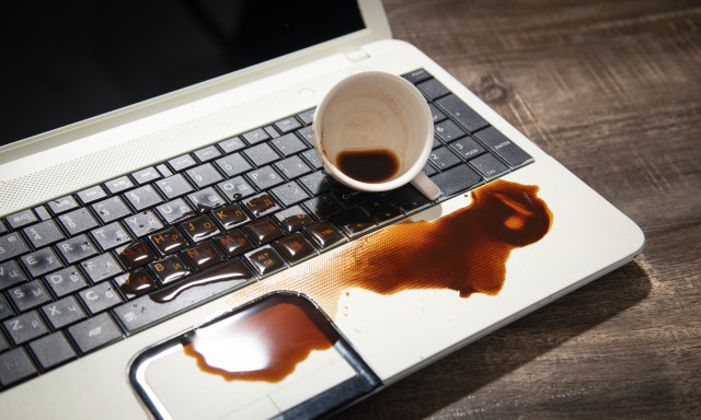 Über ein Laptop geschütteter Kaffee